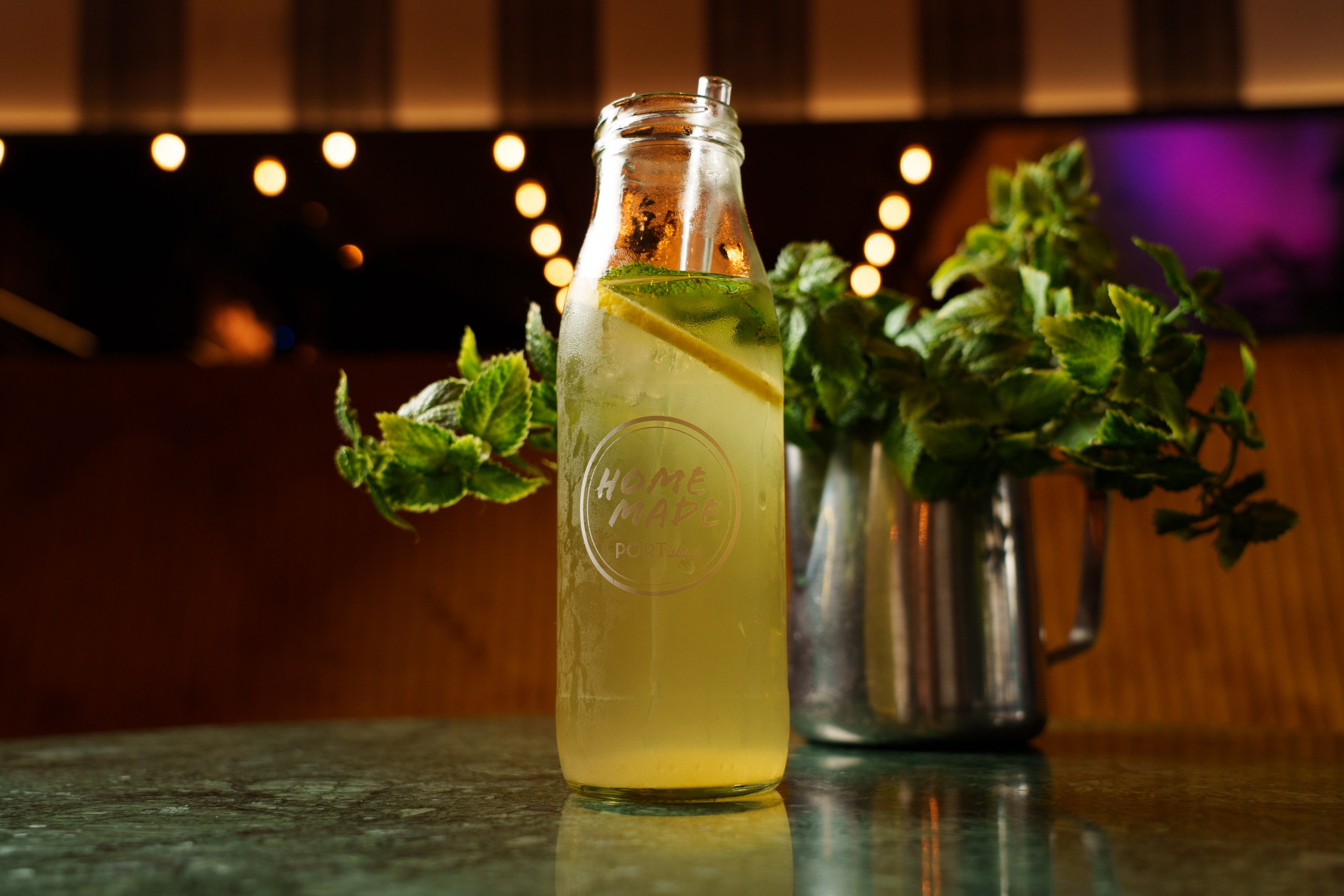 Erfrischendes gelb-grünes Getränk mit Zitrone und Minze am Hamburger Tisch der Hafeninsel. Port Island Hamburg