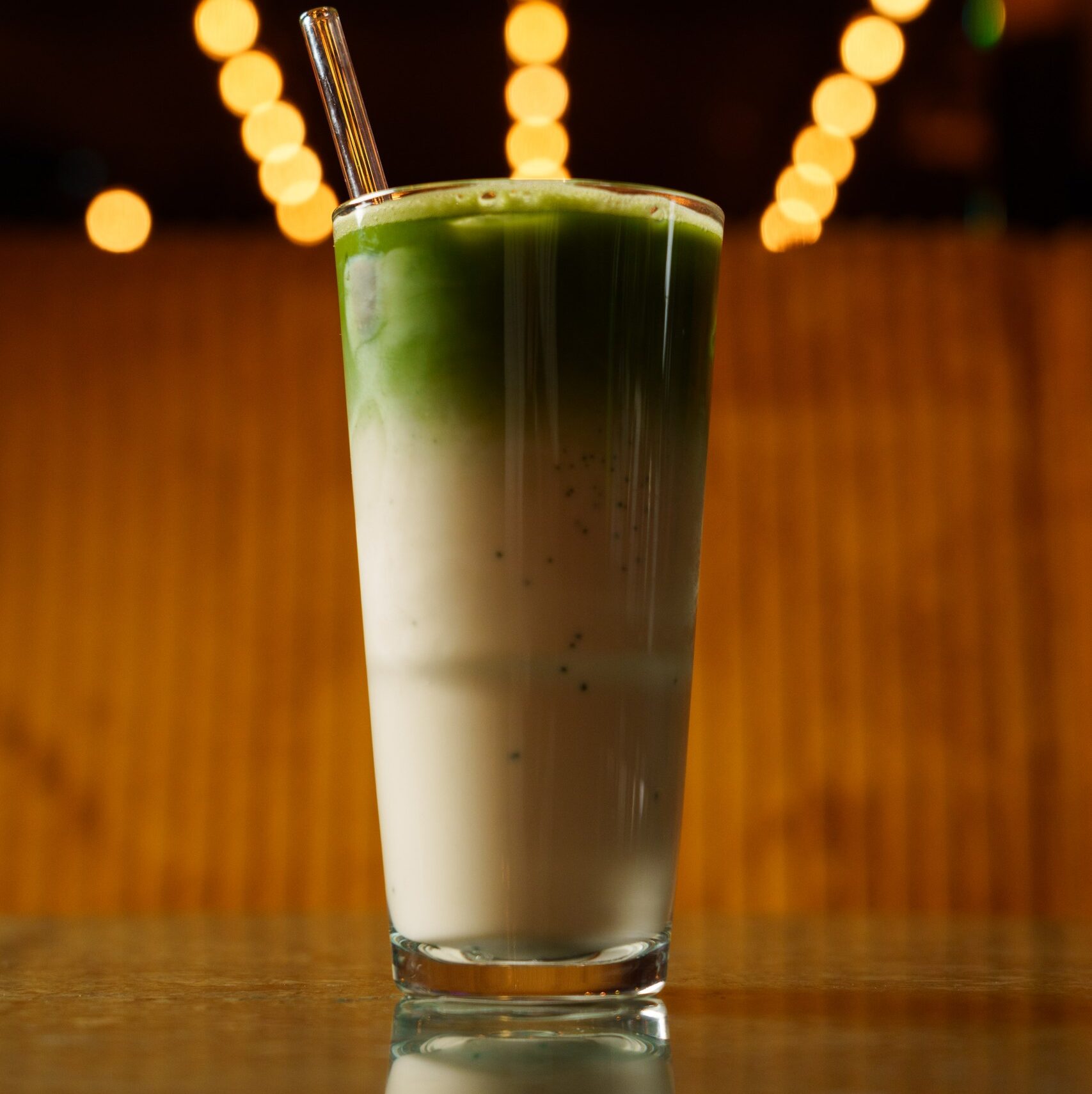 Geeister Matcha Latte in einem Glas mit Milch, serviert im Port Island Hamburg. Port Island Hamburg
