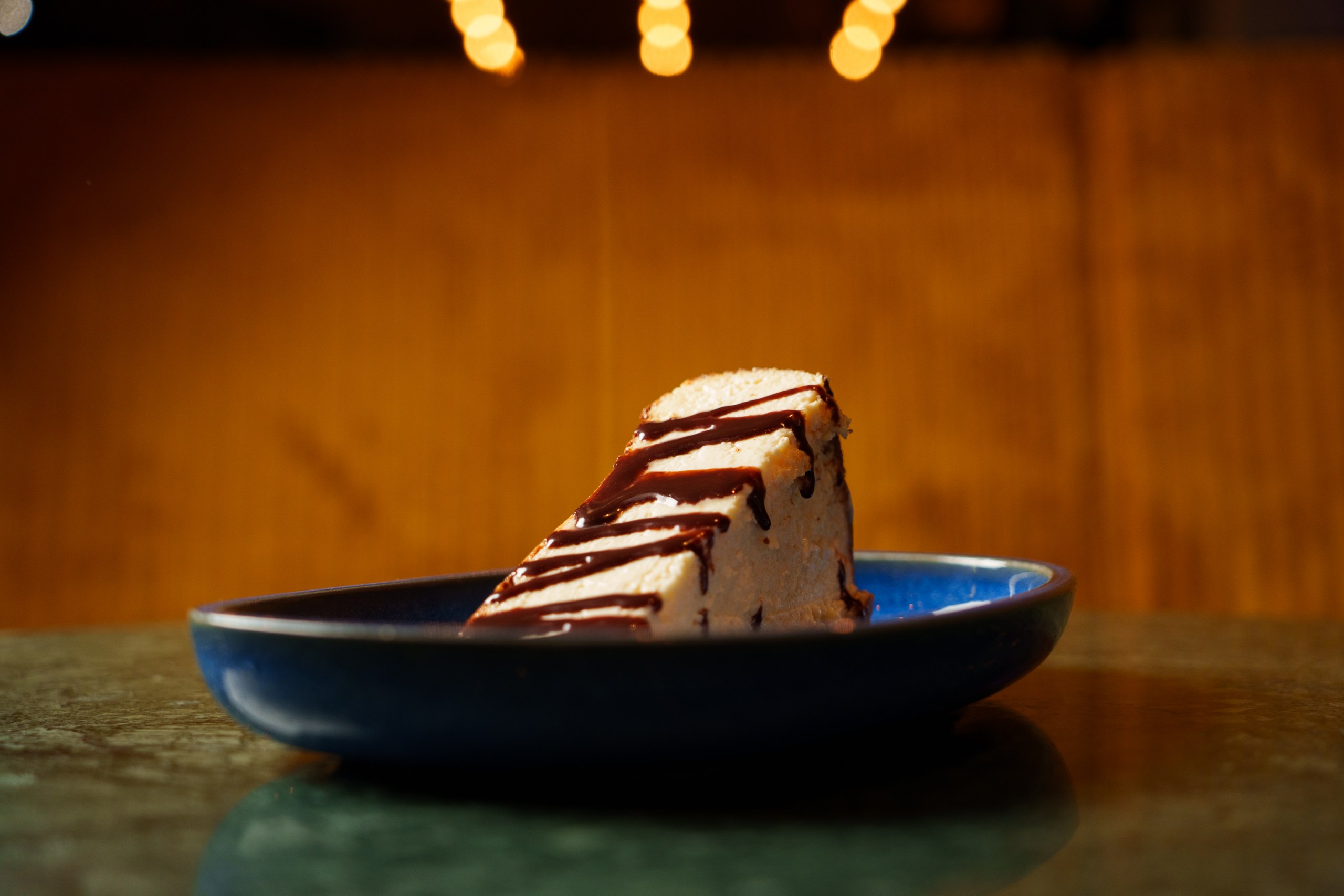 Schokoladenkuchenstück auf blauem Teller, Port Island Hamburg Café Dessert Szene. Port Island Hamburg Sweets